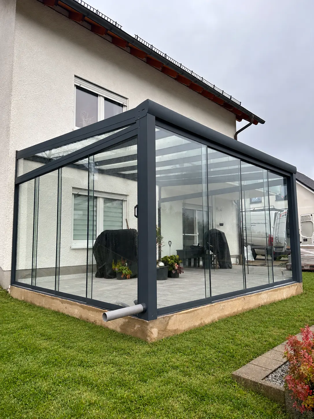Glasschiebewände am Kaltwintergarten mit Terrassenplatten